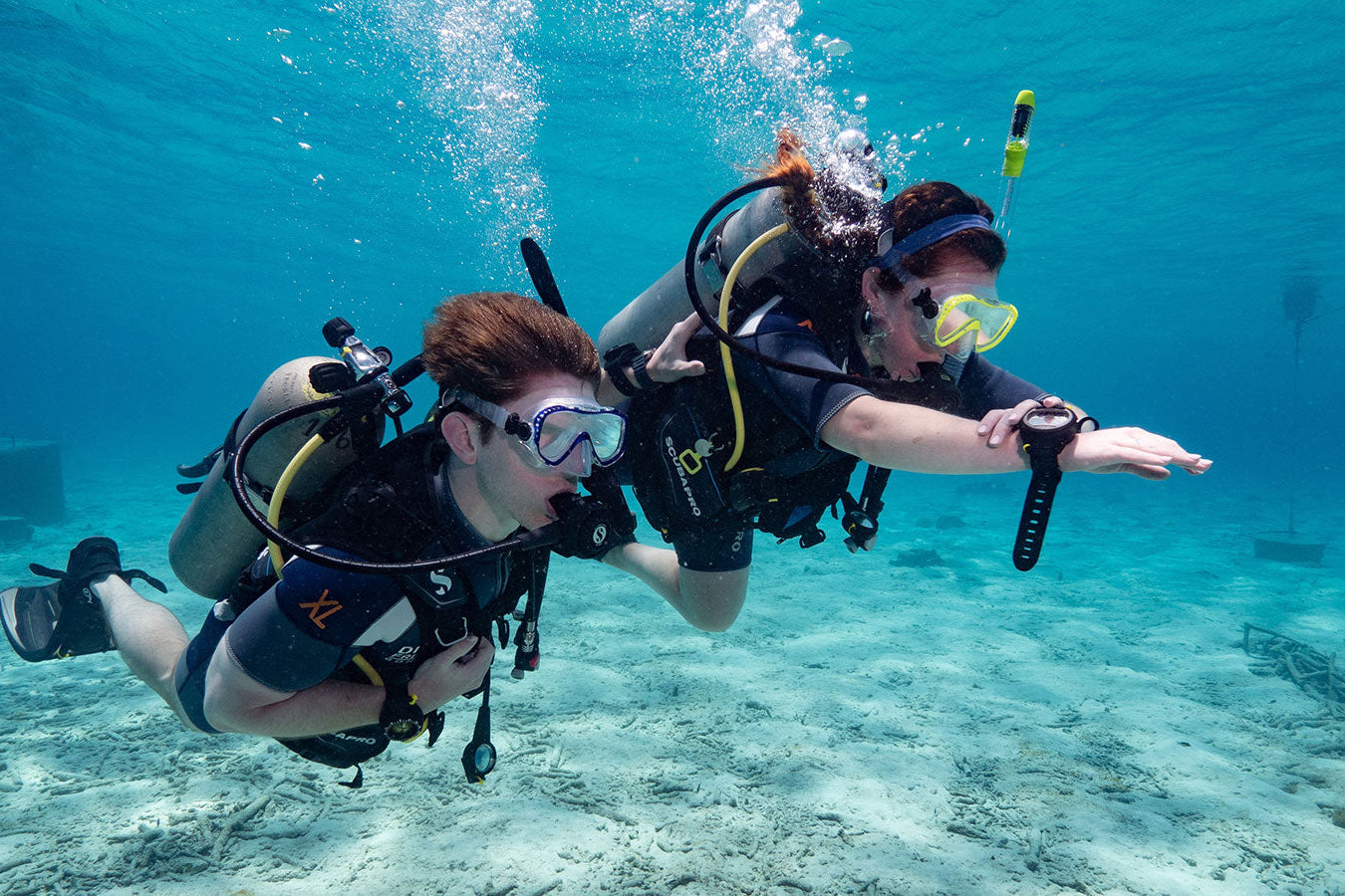 Two scuba divers underwater in clear blue water
